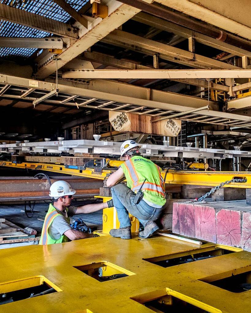 Two men in work gear with heavy equipment